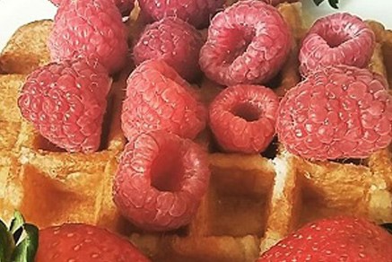 Yummy Raspberries layered ontop of a Belgian waffle.